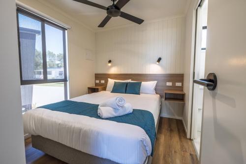 a bedroom with a bed with a towel on it at BIG4 Ulladulla Beachside Holiday Park in Ulladulla