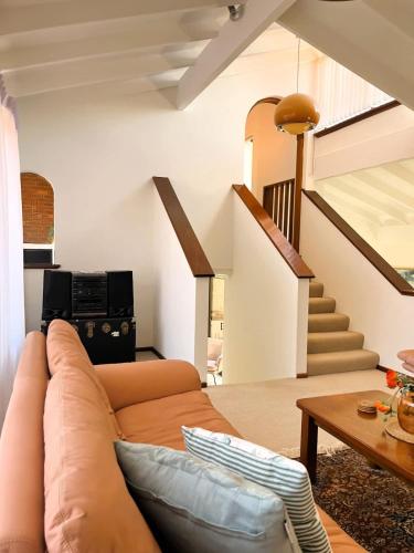 a living room with a couch and a staircase at 17 Rare Cool Urban-Style Nedlands 4BR-Parkng&Pool in Perth