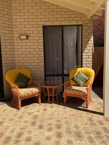 two wicker chairs and a table on a patio at 17 Rare Cool Urban-Style Nedlands 4BR-Parkng&Pool in Perth