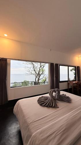 a bedroom with a large bed with a large window at Nunggalan Octopus 2 in Uluwatu