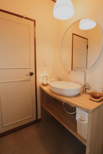 a bathroom with a sink and a mirror at 愛犬と休日を過ごすサウナハウス-COZY HOUSE Izukogen- in Ito
