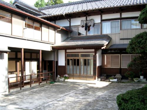 a building with a courtyard with a large door at Hagurokan in Tsuruoka