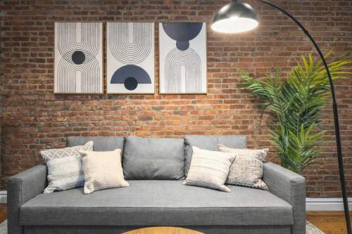 a couch in a living room with a brick wall at Modern Manhattan Haven Near Everything in New York