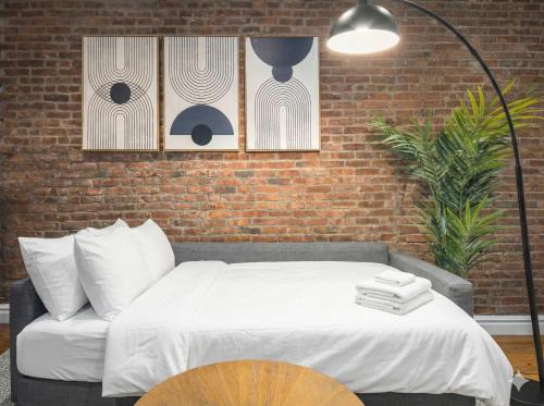 a bedroom with a bed and a brick wall at Modern Manhattan Haven Near Everything in New York