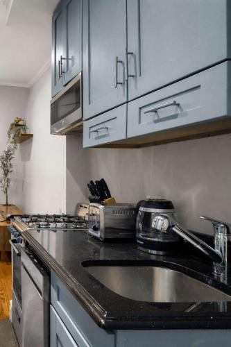 a kitchen with a sink and a counter top at Modern Manhattan Haven Near Everything in New York