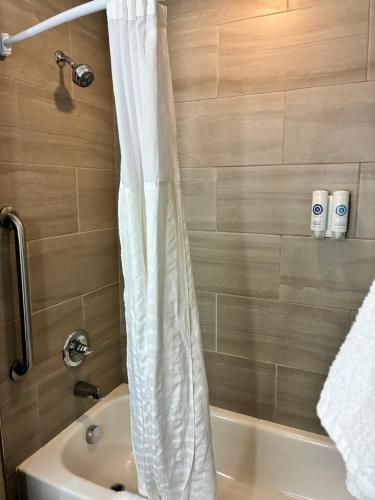 a bathroom with a shower curtain next to a tub at Comfort Inn & Suites Sterling in Sterling