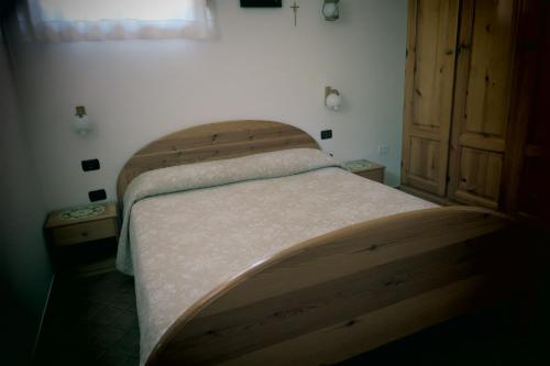 - un lit dans une chambre avec une tête de lit en bois dans l'établissement Casa Monika, à Gasponi