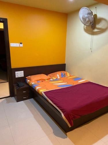 a bed in a room with a yellow wall at Hotel Swagat Residency in Panhāla