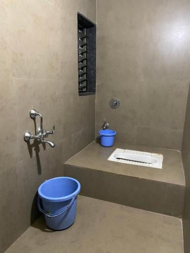 a bathroom with a blue bucket and a sink at Hotel Swagat Residency in Panhāla