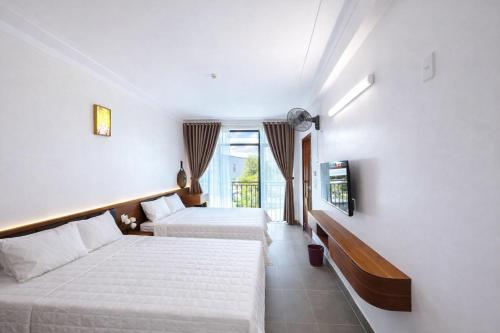 a hotel room with two beds and a tv at Thành Trung Hotel Nghệ An in Vinh
