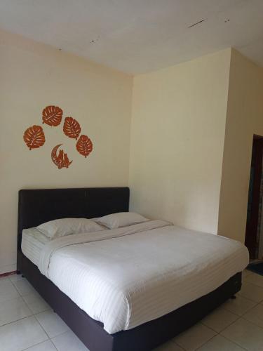 a bedroom with a bed with shells on the wall at Askara Toba Cottage in Tuktuk Siadong