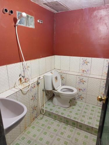 a bathroom with a toilet and a sink at Askara Toba Cottage in Tuktuk Siadong