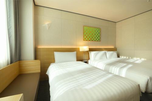 a hotel room with two beds and a window at Orakai Cheonggyesan Hotel, BW Premier Collection in Seoul