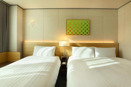 two beds sitting next to each other in a room at Orakai Cheonggyesan Hotel, BW Premier Collection in Seoul