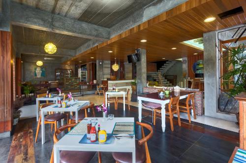 a restaurant with tables and chairs in a room at Memory Patong - SHA Certified in Patong Beach