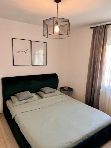 a bed with a green headboard in a bedroom at Transylvanian Nomad II in Cluj-Napoca
