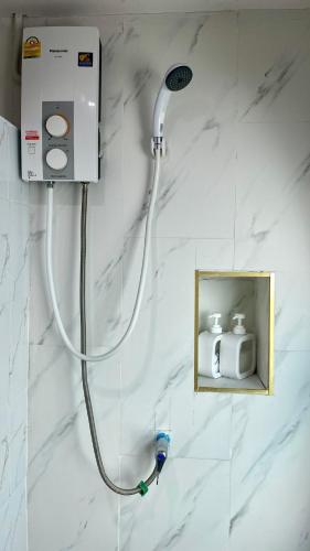 a shower with a hose hooked up to a wall at Andaman Beach Resort by Zodiac in Ko Lipe
