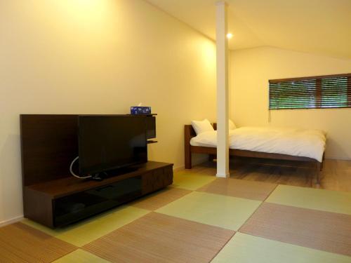 a living room with a tv and a bed at A-PLAZA Yamanakako in Yamanakako