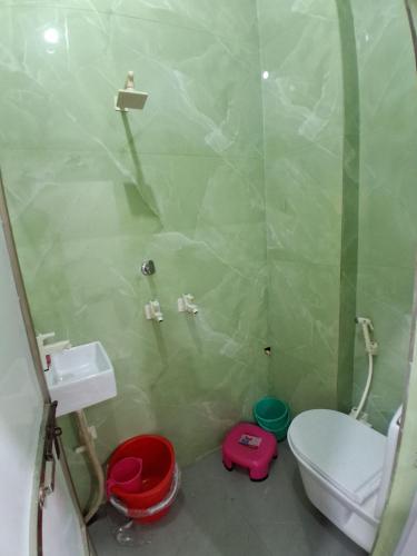 a bathroom with a shower and a toilet and a sink at JSRInn in Mathura