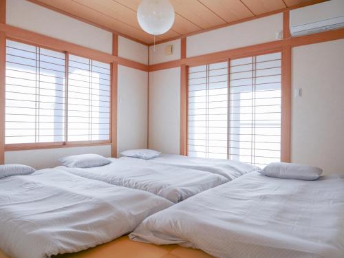 two large beds in a room with windows at 9Stay市原 in Ichihara