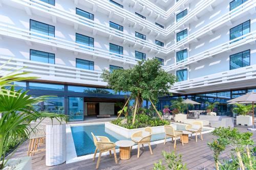 an exterior view of a building with a swimming pool at The Royal Park Hotel Iconic Naha in Naha
