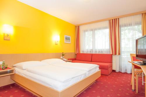 a bedroom with a bed and a couch and a television at Hotel zur Post in Sankt Valentin