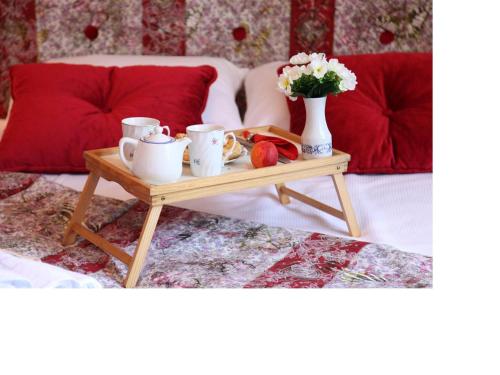 a table with cups and a vase with flowers on it at Apartment Alloga in Belgrade