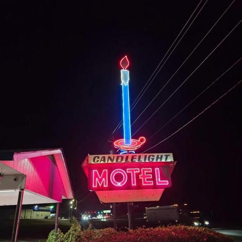 a sign for a motel with a neon sign at Candle Light Motel in Ozark
