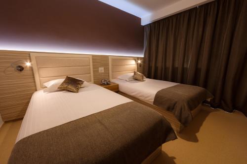 a hotel room with two beds and a window at Premium Wellness Institute in Bucharest