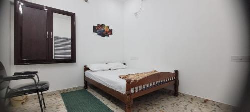 a small bedroom with a bed and a mirror at Krishna stays in Manattala