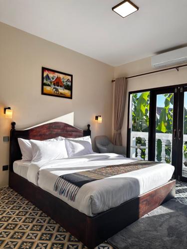 a bedroom with a large bed and a window at The TARA PRABANG - Luangprabang in Luang Prabang