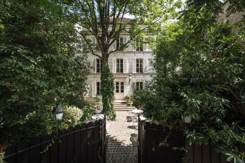 une clôture devant une maison avec un arbre dans l'établissement Hôtel Particulier Montmartre, à Paris