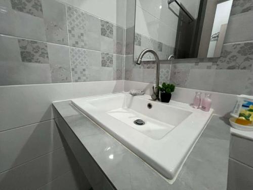 a white bathroom with a sink and a mirror at SRE- JOY Holiday Home in Mae Sot in Mae Sot