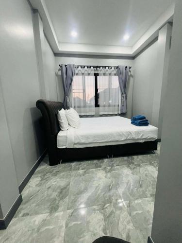 a bedroom with a large bed and a window at SRE- JOY Holiday Home in Mae Sot in Mae Sot