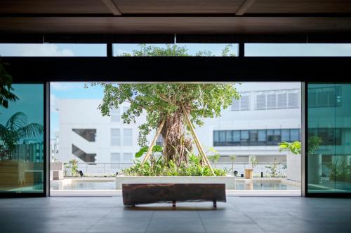 a bench in front of a tree in a building at The Royal Park Hotel Iconic Naha in Naha