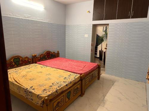 a bedroom with a bed with a red comforter at Jacobs Cottage KG-F1 in Thiruchendur