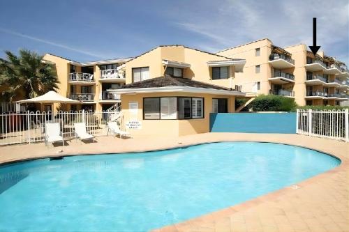 a swimming pool in front of a building at The White Pearl Apartment Direct Ocean Views Top Floor in Perth