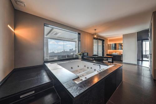 a large bath tub in a room with a large window at Hotel Hills in Paju
