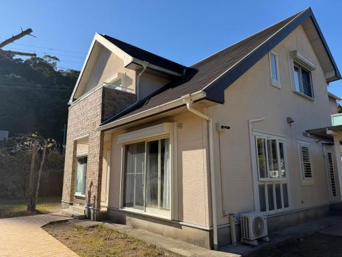 a white house with a window and a roof at 熊野古道の宿大門坂 in Nachikatsuura
