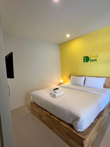 a bedroom with a bed with a yellow wall at เดย์ อิน in Ban Nong Sua Chang