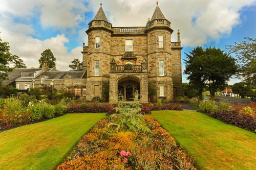 an old stone house with a garden in front of it at Dalmahoy Hotel & Country Club in Edinburgh