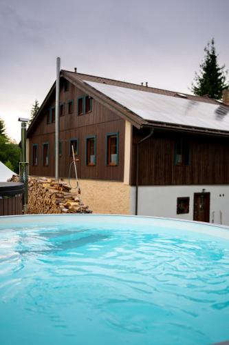 a house with a swimming pool in front of a house at Chata Polka in Horní Vltavice