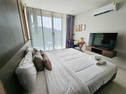 a bedroom with a large bed and a television at patong see view condo in Patong Beach