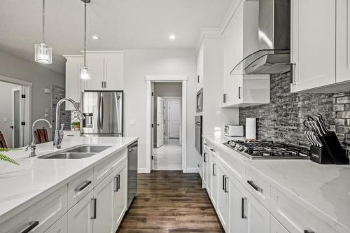 a kitchen with white counters and a stove top oven at Luxury Retreat For Large Groups in Calgary