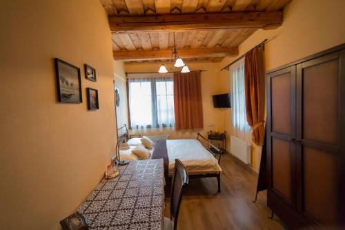a bedroom with a bed and a table in a room at Penzión Banská Klopačka in Hnilčík