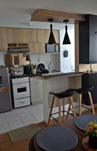 a kitchen with a counter and two chairs in it at Cesar's Apartment - Los Laureles in Lima