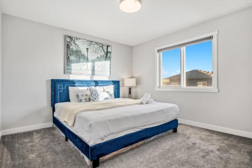 a bedroom with a blue bed and a window at Luxury Retreat For Large Groups in Calgary