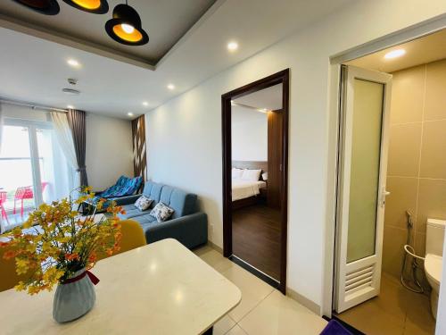 a living room with a blue couch and a mirror at Mermaid Seaside Condotel in Vung Tau