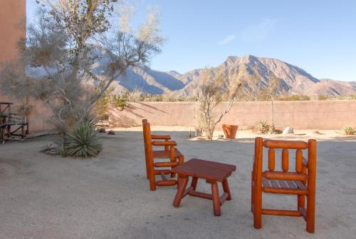 two chairs and a table in front of a wall at Borrego Valley Inn in Borrego Springs
