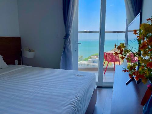 a bedroom with a bed and a view of the ocean at Mermaid Seaside Condotel in Vung Tau